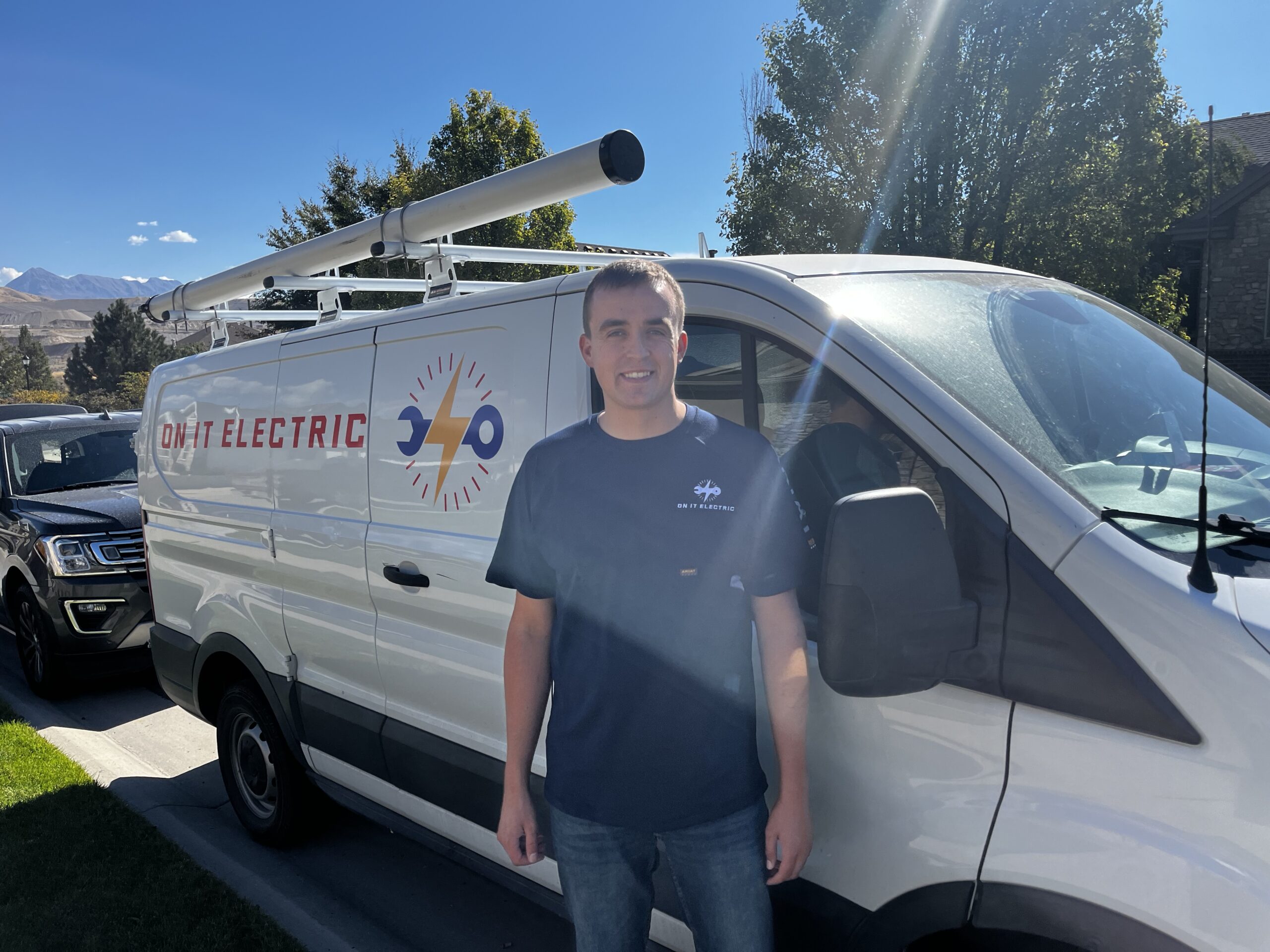 A man stands in front of a white van with 